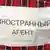 Лист бумаги с надписью "Иностранный агент. Прямая трансляция в Госдеп", приколотый на спине мужчины во время демонстрации в Санкт-Петербурге, апрель 2013 года