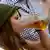 A young woman wearing traditional Bavarian dress  enjoys a beer during the Oktoberfest beer festival in Munich in 2012
