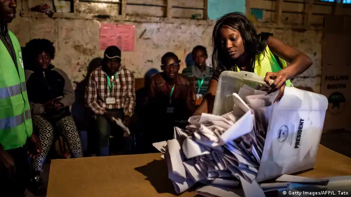 A woman pours ballots on a table