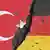 Трещина между нарисованными на асфальте флагами Турции и Германии
