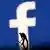 A figurine is seen in front of the Facebook logo