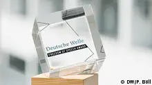 DW's Freedom of Speech Award is a glass cube mounted on a wooden base