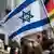 Человек в кипе на демонстрации в Бонне и флаги Израиля и Германии