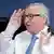 Jean-Claude Juncker with right hand raised in a seeming salute