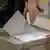 Ballot paper being put into box