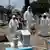 Cemetery workers wearing protective suits complete the burial of a man, who died of the coronavirus disease