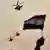 Three helicopters fly past an Egyptian flag