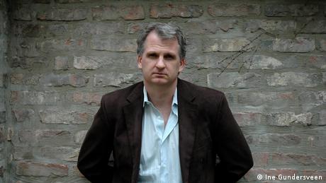 Timothy Snyder in front of a greyish brick wall