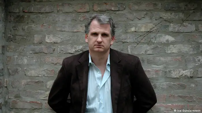 Timothy Snyder in front of a greyish brick wall