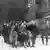 Photo de février 1943 qui montre un groupe de juifs polonais qui avance en rang, certains les mains en l'air, sous la surveillance de soldats de la Waffem-SS
