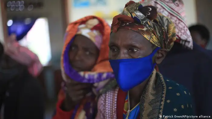 Uganda | Eine Frau warte auf eine COVID-19 Impfung