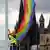 A rainbow flag being hung in front of a cathedral