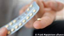 Hand holding contraceptive pills