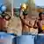 Workers use their helmets to pour water to cool themselves in Ahmedabad, India