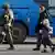 Мужчина с ребенком идет с завода "Азовсталь" к автобусу в сопровождении российского военного     