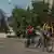 Un hombre y dos menores huyen de las bombas rusas en bicicleta, en Lisichansk, Ucrania.