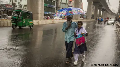 Bangladesch Dhaka | Vater und Tochter unter Regenschirm auf der Straße