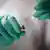 Eldivenli ellerin tuttuğu bir aşı ile bir aşı tüpü