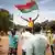 Image d'un homme tenant un drapeau du Burkina Faso