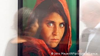 In this picture a woman is looking at the photo 'Afghan Girl' (Pakistan, 1984) during the exhibition 'Steve McCurry Retrospective' of the US photographer at Kunsthalle in Erfurt, Germany
