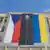 На полотне, закрывающем около 15 окон здания, вертикально изображены флаги Чехии и Украины. Между ними вставка с фигурой президента РФ Путина, которую как будто застегивают в черном коконе.