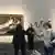 Spanish climate activists stand with their hands glued to matching Goya paintings as a museum guide seeks to restore order