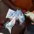 A man holds cedis, the Ghana currency, notes in Accra, Ghana.