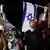 Protesters carying Israeli flags and posters on the streets of Tel Aviv