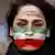 A woman with her face painted in the colors of the Iranian flag in a protest in solidarity with Iranian people.