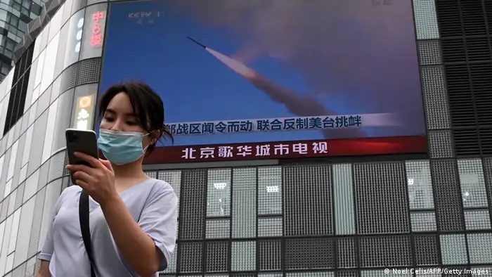 圖為去年北京街頭的螢幕上，正播放新聞報導中國包圍台灣的軍事演習。
