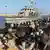 Des migrants secourus assis à côté d'un bateau des garde-côtes dans la ville de Khoms, en Libye, à environ 120 kilomètres à l'est de Tripoli (01.10.2019)