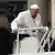 Papa Francisco se apoia em barras de metal para entrar no papamóvel.