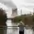 Man standing on bridge overlooking nuclear power plant Isar 2