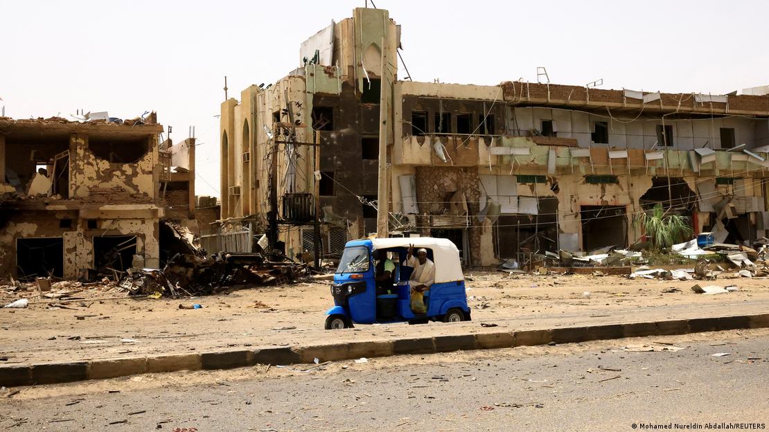 Sudan'daki çatışmalarda ağır hasar gören, başkent Hartum'un kuzeyindeki kapalı pazar binası ve önünden geçen bir araç - (27.04.2023)