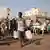 People gather to collect water in Khartoum, Sudan, Sunday, May 28, 2023.