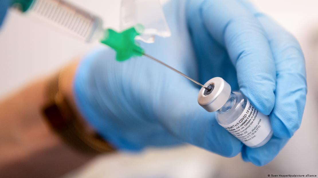 Deutschland, Bayern, Gauting | Covid Impfung wird mit Spritze aufgezogen