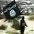 شام میں داعش کا ایک جنگجو اس دہشت گرد تنظیم کا پرچم اٹھائے ہوئے، دو ہزار سولہ میں لی گئی ایک تصویر