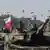 Militärparade mit einigen Soldaten auf Panzern, in einem steckt die weiß-rote polnische Flagge