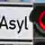 Стрелка светофора на красном фоне указывает на надпись Asyl ("Убежище")