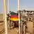 German Bundeswehr soldiers stationed in Mali as part of the UN's MINUSMA peacekeeping mission lower their flag as they prepare to abandon Camp Castor in the city of Gao