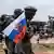 Orta Afrika Cumhuriyeti'nde elinde silah tutan bir savaşçı heykelinin koluna iliştirilmiş olan Rusya Federasyonu bayrağı ve bunun fotoğrafını çeken kişiler - (22.03.2023 / Bangui)