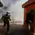 Des manifestants masqués et armés de pierres courent pour échapper à la police à Dakar