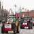 Tractors with red-and-white signs and Polish flags drive along a street. Buildings and the cranes in the port of Gdansk can be seen in the background, Poland, February 20, 2024