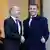 Olaf Scholz shaking hands and smiling with Emmanuel Macron 