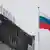 Флаг России и обгоревшее здание делового центра "Крокус Сити" в Красногорске