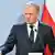 Premier Polski Donald Tusk, w tle flaga biało-czerwona