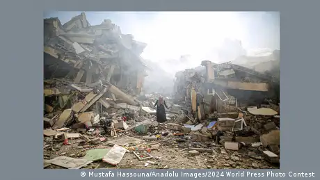 Eine Frau steht in einem Trümmerfeld